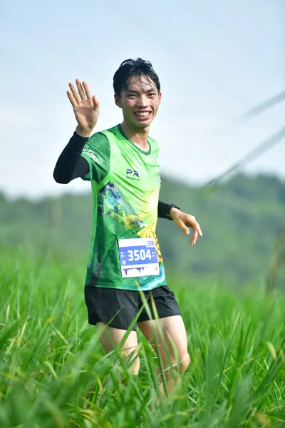 Marathon runner #3504: Runner 1: green patterned jersey, black long sleeves, black shorts