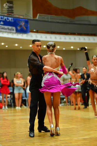 Dancesport competitor: Male dancer: black semi-sheer long-sleeved shirt and black trousers