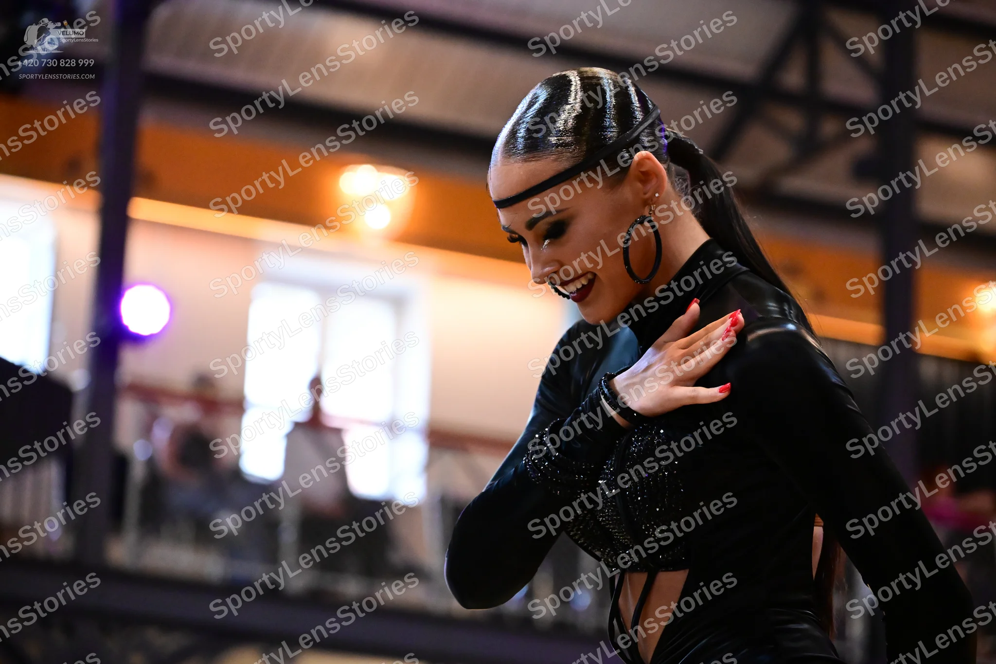 Dancesport competitor: Female dancer: black long-sleeved Latin costume with sequins and large black hoo