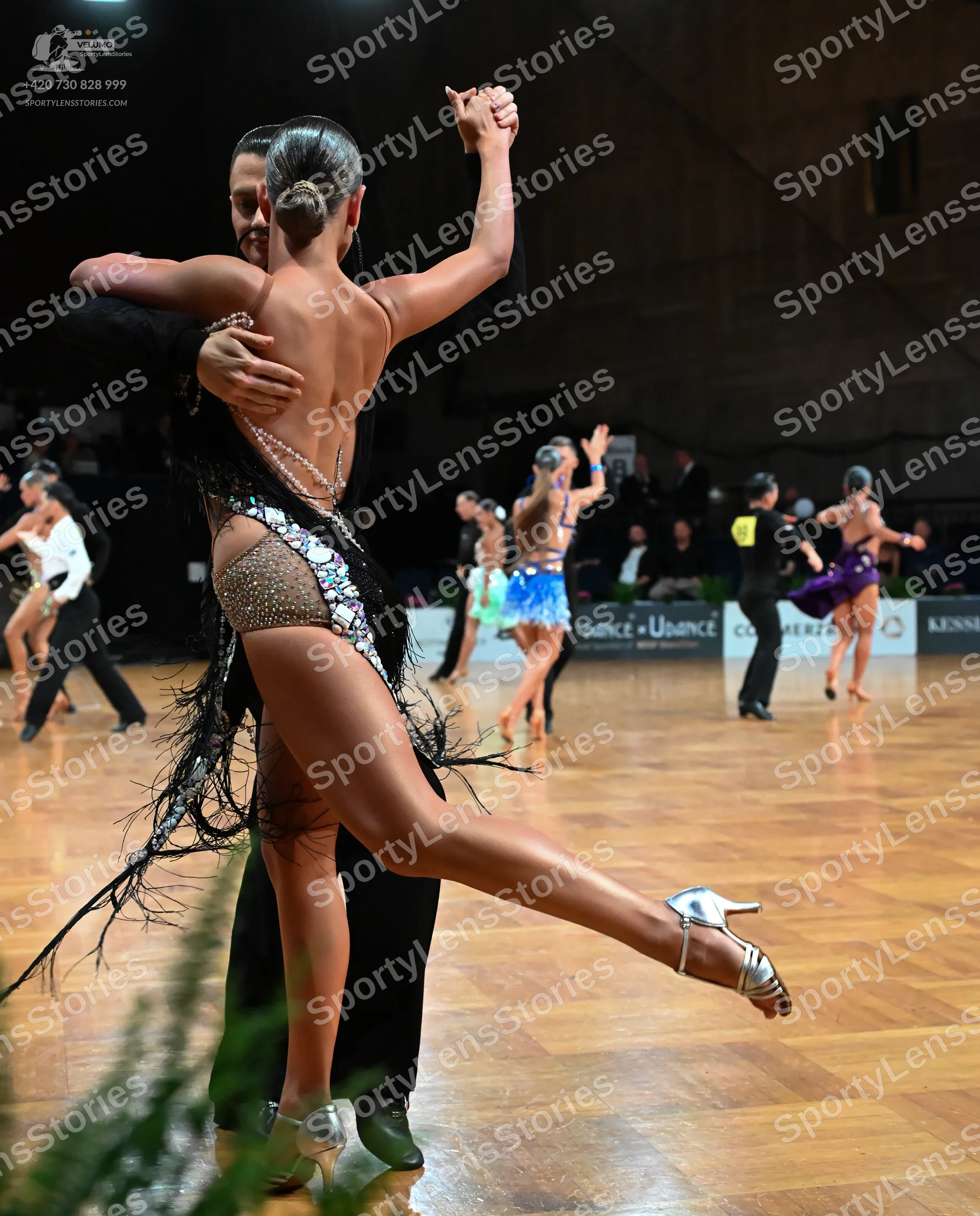 Dancesport competitor: Foreground female dancer: nude-colored latin dress with silver sequins, beads, a