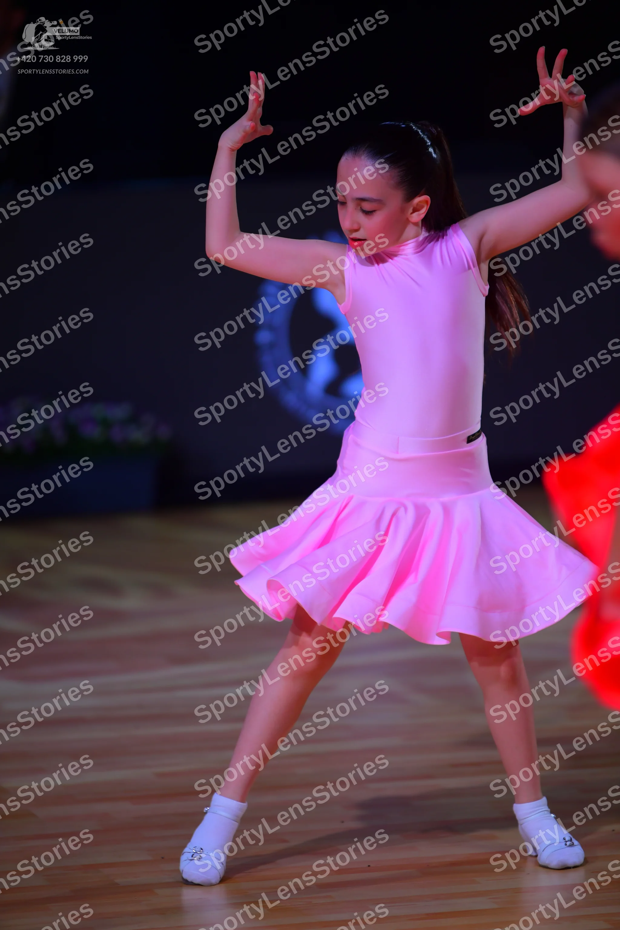 Dancesport competitor: Female dancer: pink sleeveless Latin dress with a flared skirt
