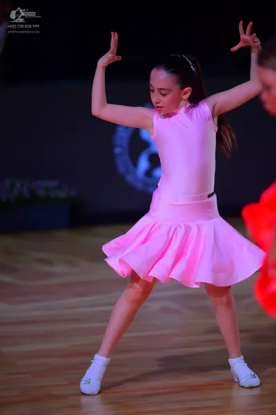 Dancesport competitor: Female dancer: pink sleeveless Latin dress with a flared skirt
