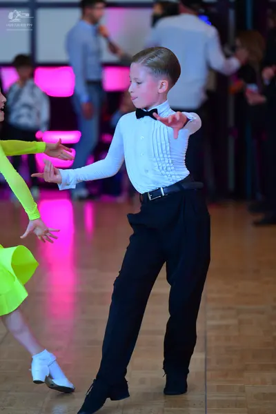 Dancesport competitor: Male dancer: white long-sleeved pleated shirt, black bow tie, and black trousers