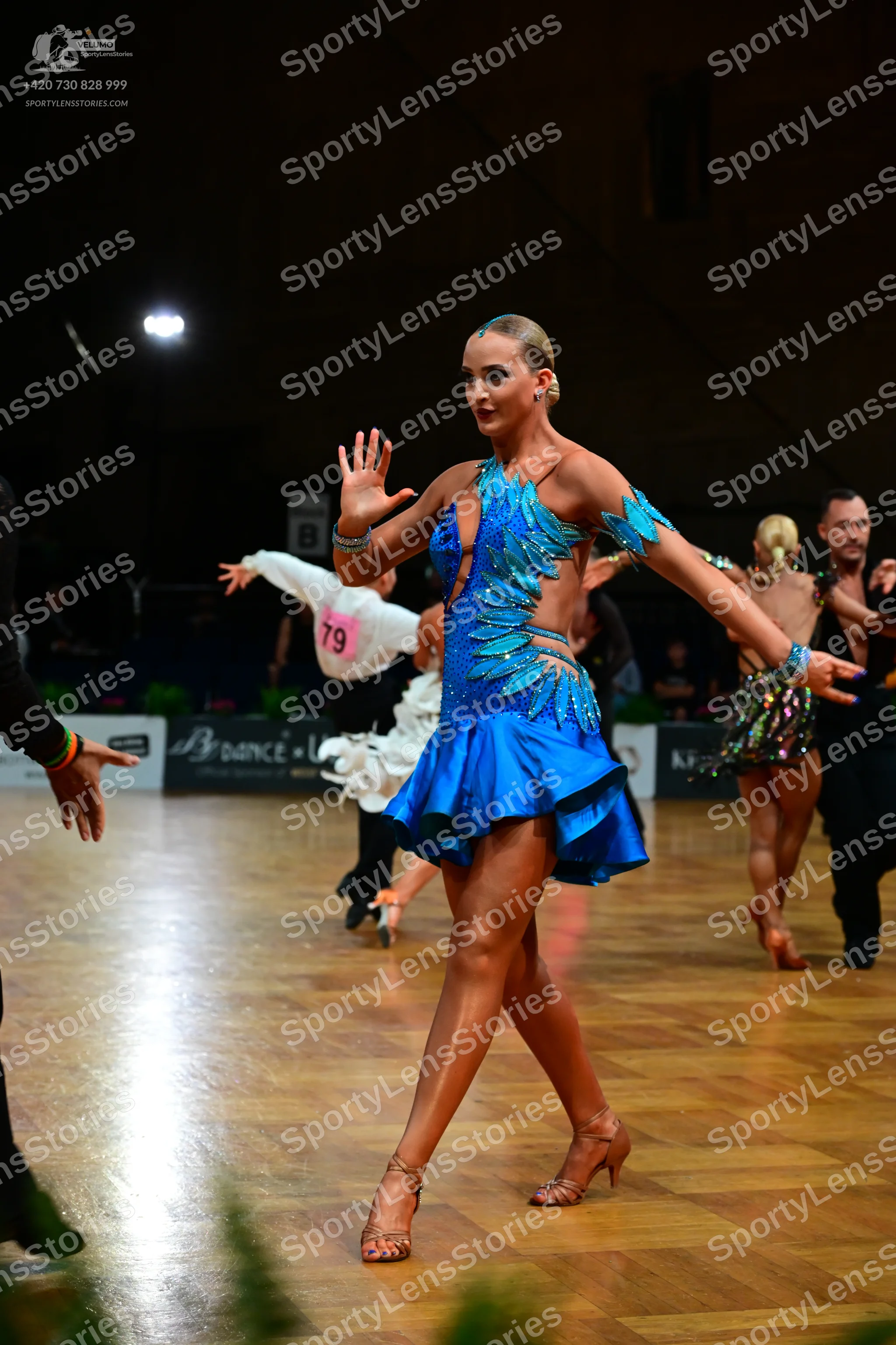 Dancesport competitor #79: Main female dancer: blue Latin dress with teal sequin patterns, cutouts, and a s