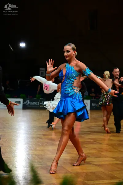 Dancesport competitor #79: Main female dancer: blue Latin dress with teal sequin patterns, cutouts, and a s