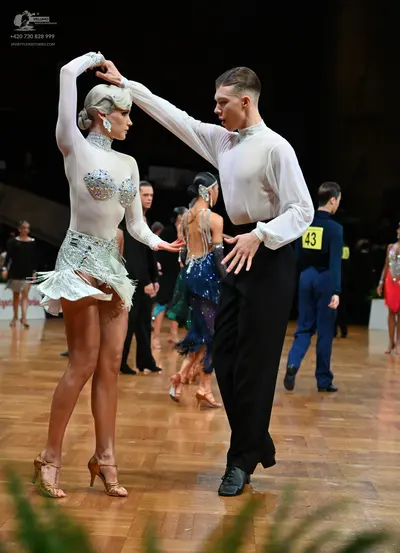 Dancesport competitor #43: Foreground female dancer: white long-sleeved latin dress with a sequined/beaded 
