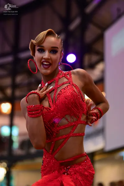 Dancesport competitor: Female dancer: red sequined Latin dress with cutouts and crisscrossing straps, m
