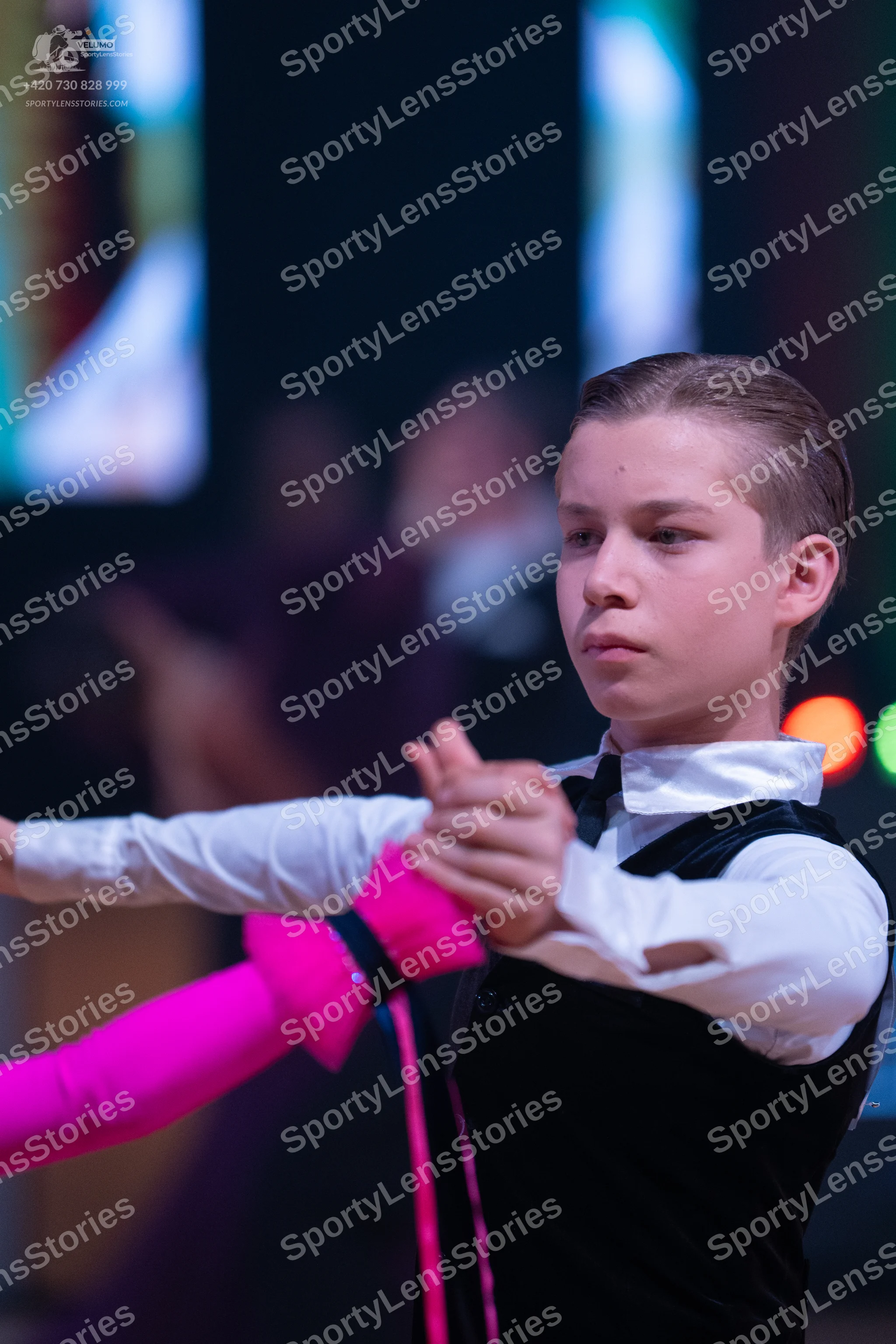 Dancesport competitor: Male dancer: black vest over a white long-sleeved shirt with a black bow tie