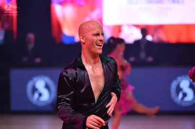Dancesport competitor: Male dancer: black satin-finish long-sleeved shirt, worn open at the chest