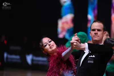 Dancesport competitor: Female dancer: deep red Latin dance dress with long feathery/fringe texture and 
