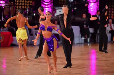 Dancesport competitor: Female dancer (left): yellow satin Latin dress with thin straps