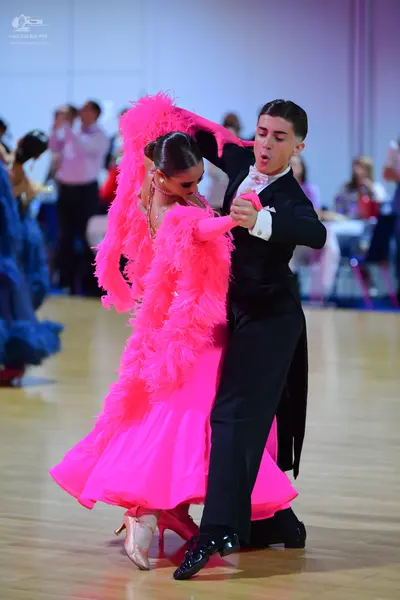 Dancesport competitor: Female dancer: bright pink ballgown with voluminous, fluffy pink feather-like tr