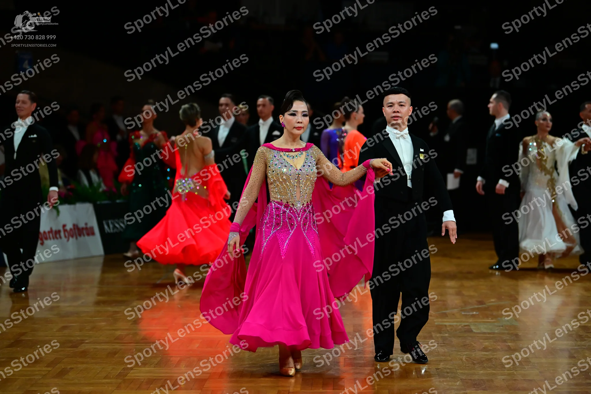 Dancesport competitor: Main female dancer: pink ballgown with large flowing chiffon sleeves and a heavi