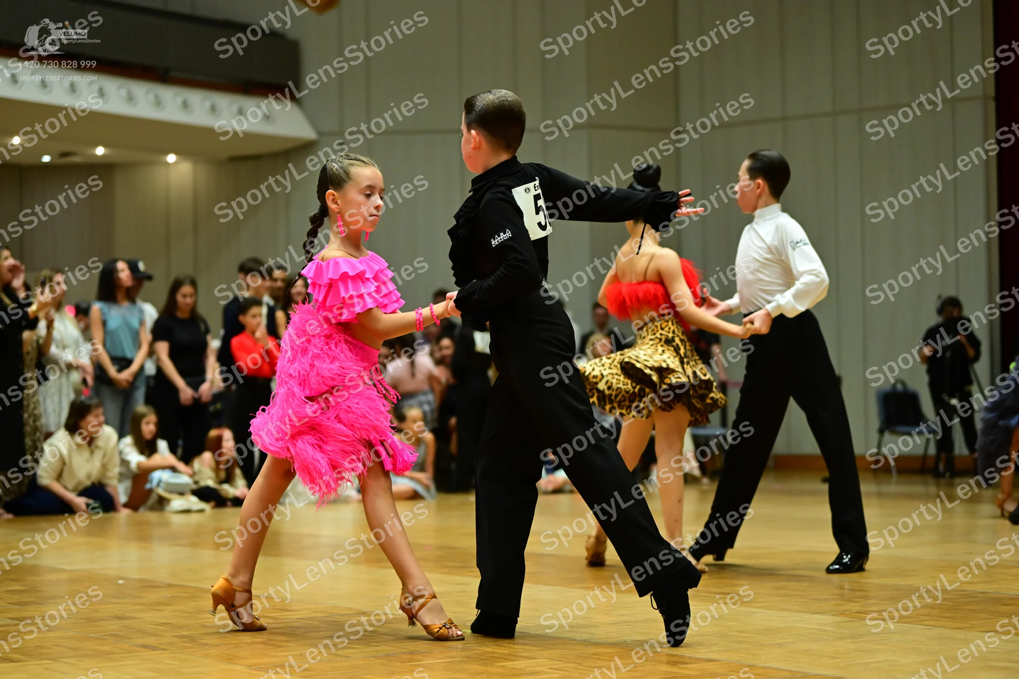Dancesport competitor: Female dancer: bright pink Latin dress with tiered fringe/ruffles