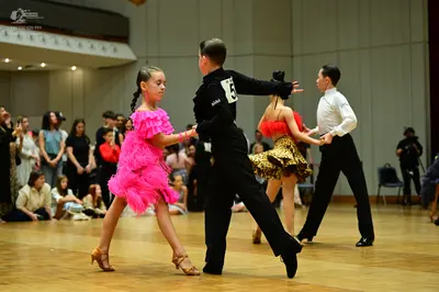 Dancesport competitor: Female dancer: bright pink Latin dress with tiered fringe/ruffles