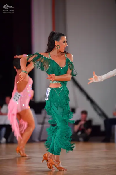 Dancesport competitor #16, #165: Female dancer in green: green latin dress with heavy fringe, sequins, and waist 