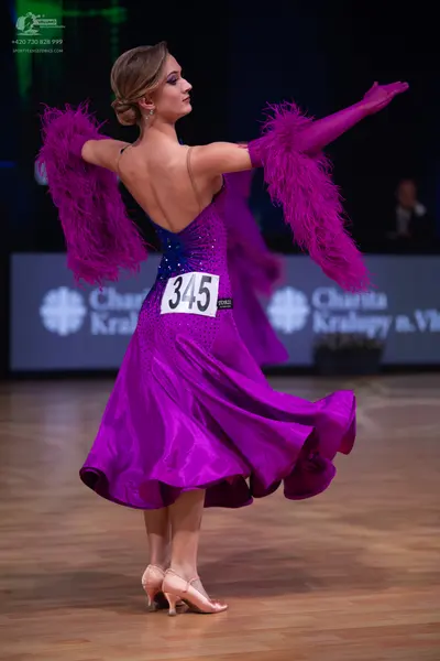 Dancesport competitor: Female dancer: purple satin ballroom dress with sequin embellishments on the bod
