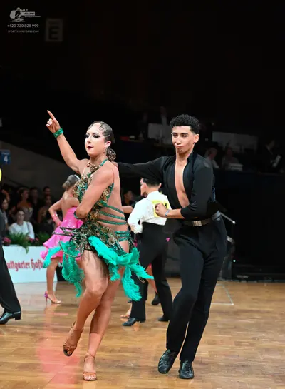 Dancesport competitor: Male dancer: black long-sleeve shirt with a small amount of skin showing at the 