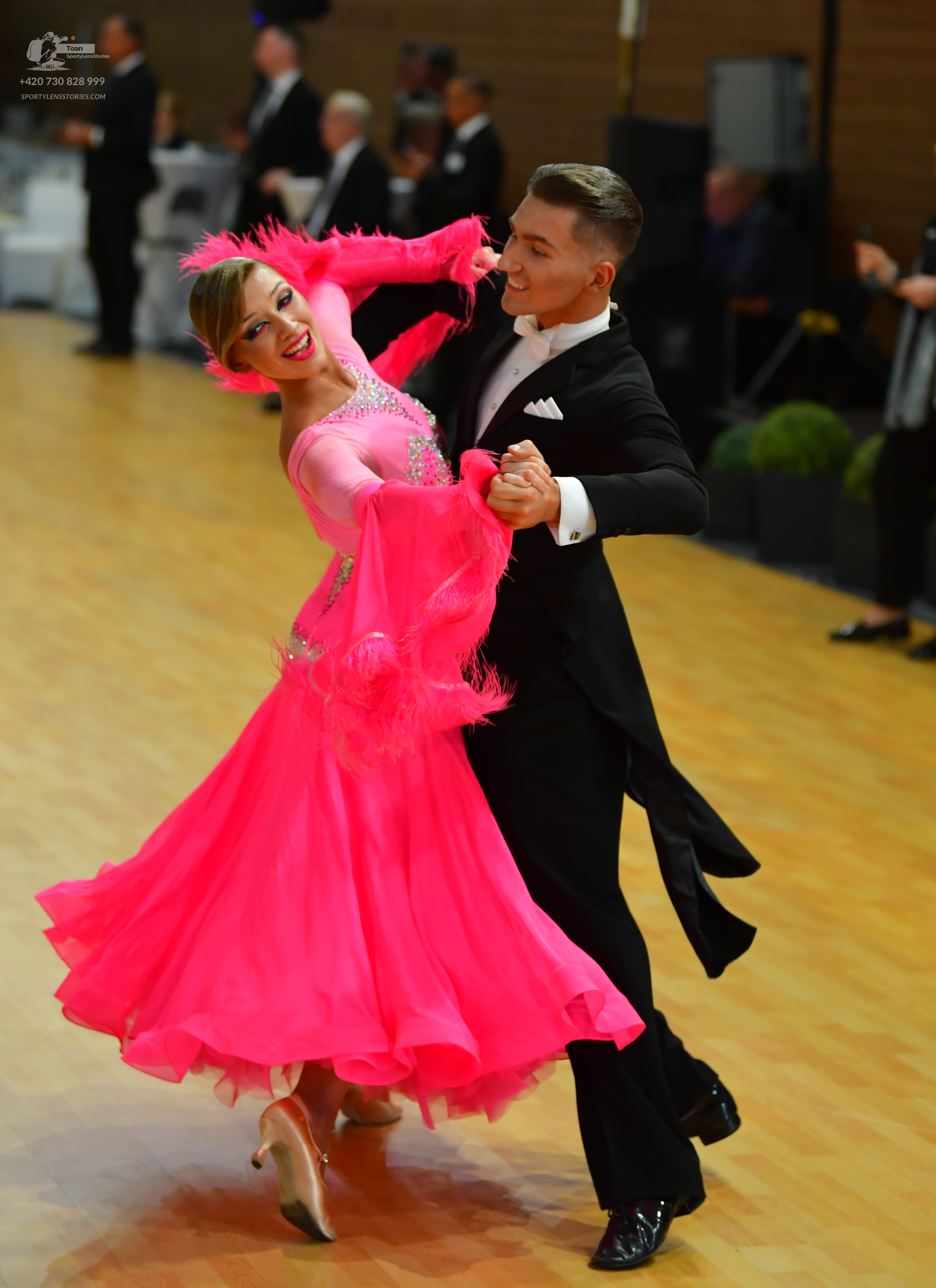 Dancesport competitor: Male** - Black tailsuit with a subtle iridescent sheen (likely satin or a simila