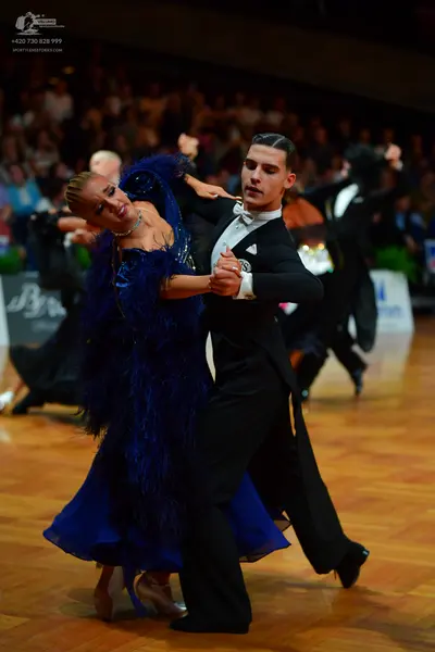 Dancesport competitor: Male dancer: black ballroom tailcoat suit, white waistcoat, white bow tie, and w