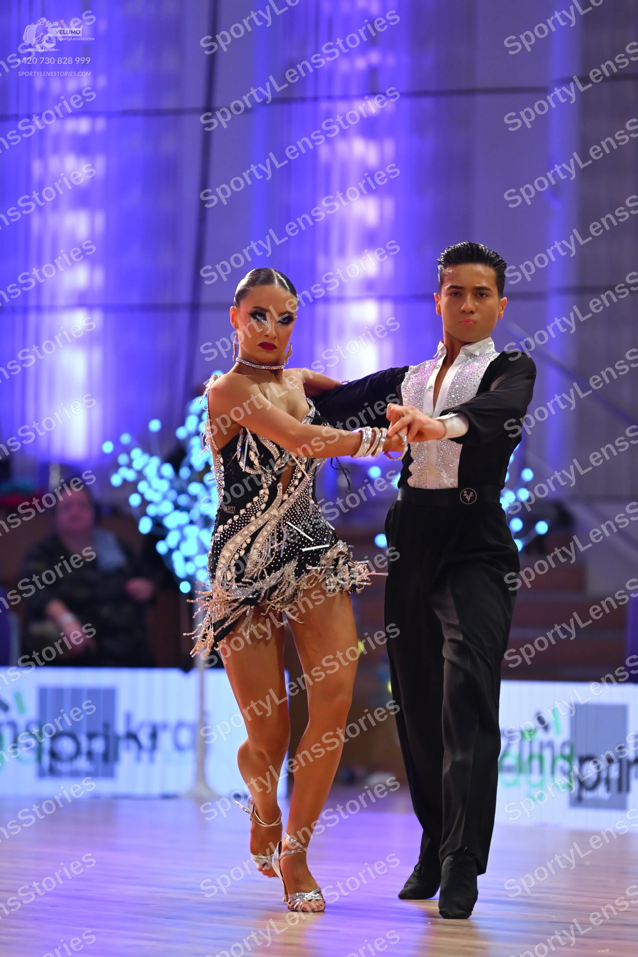 Dancesport competitor: Female dancer: black latin dress with silver/white sequin patterns and fringe de