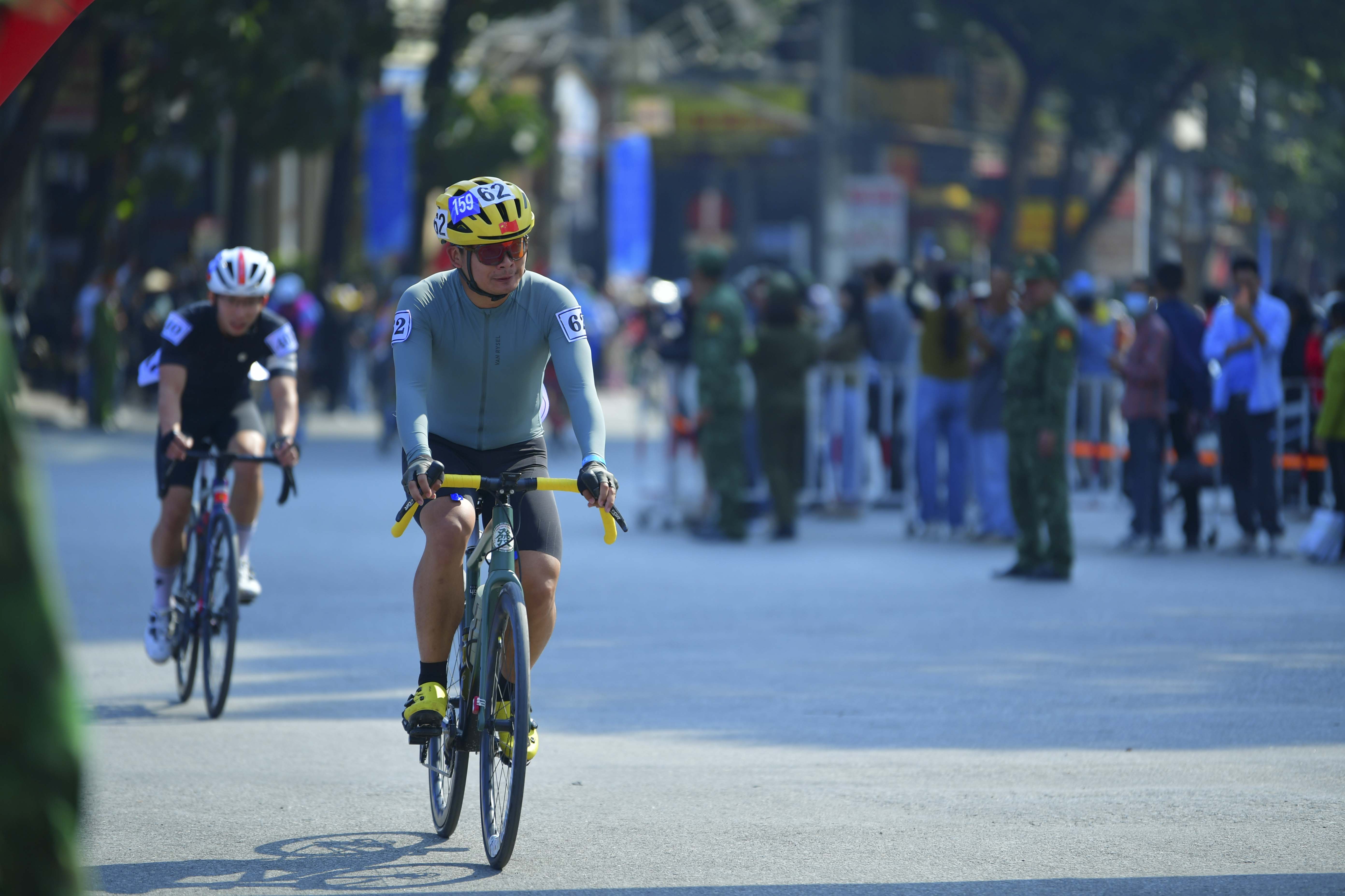 Cyclist #0159: Cyclist 1: Yellow jersey, black shorts, white/blue helmet