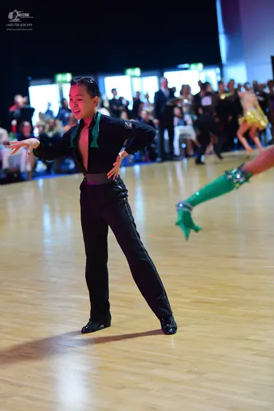 Dancesport competitor: Male dancer: black long-sleeved shirt with green sequin detail on the V-neckline