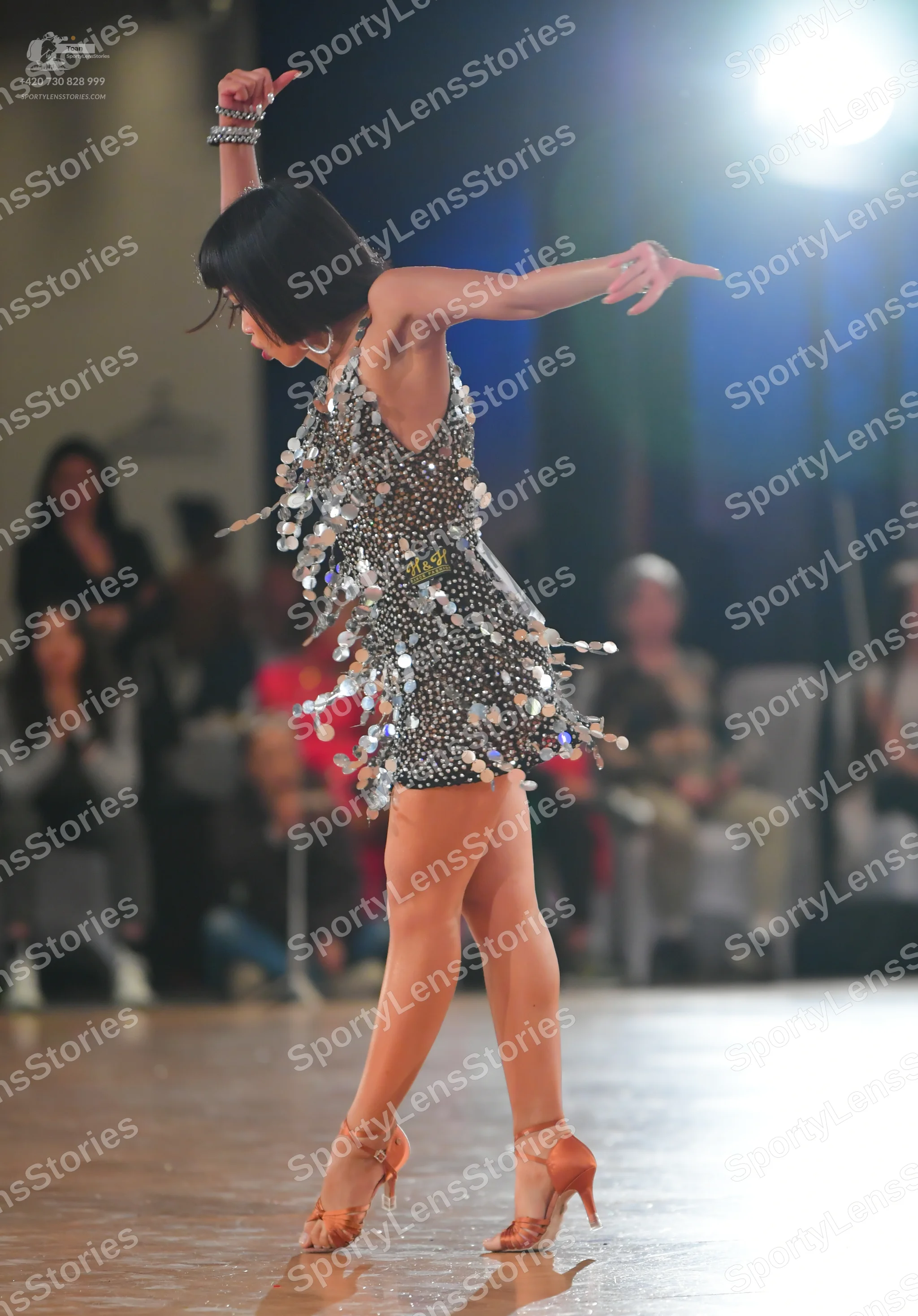 Dancesport competitor: Female dancer: black Latin dress heavily embellished with silver sequins and lar