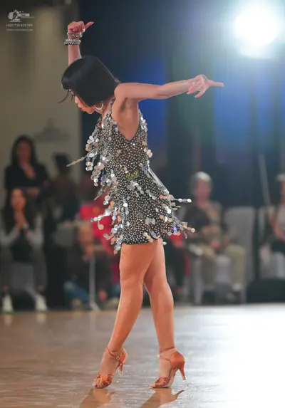 Dancesport competitor: Female dancer: black Latin dress heavily embellished with silver sequins and lar
