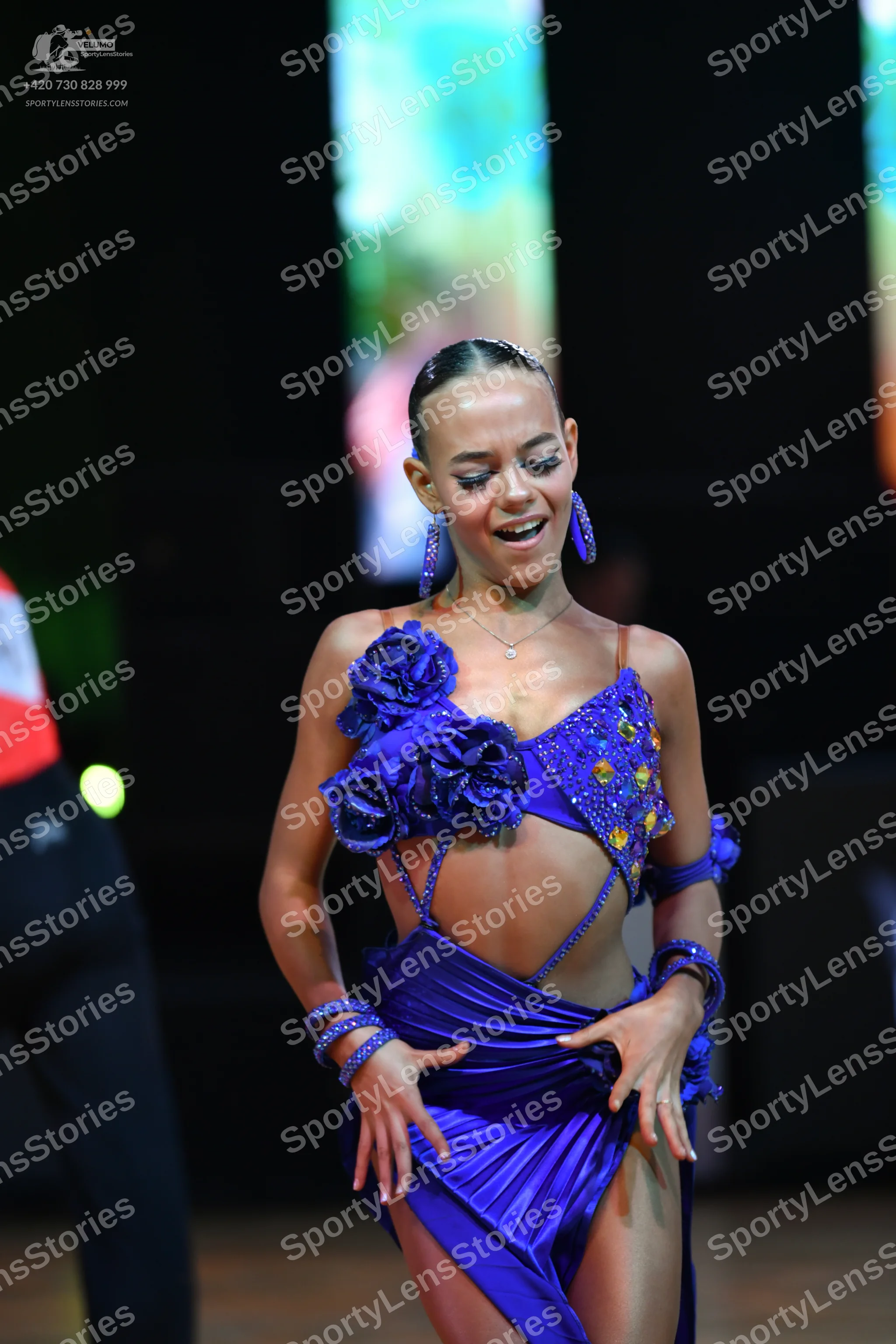 Dancesport competitor: Female dancer: Royal blue latin dress with satin-like fabric, featuring large fa