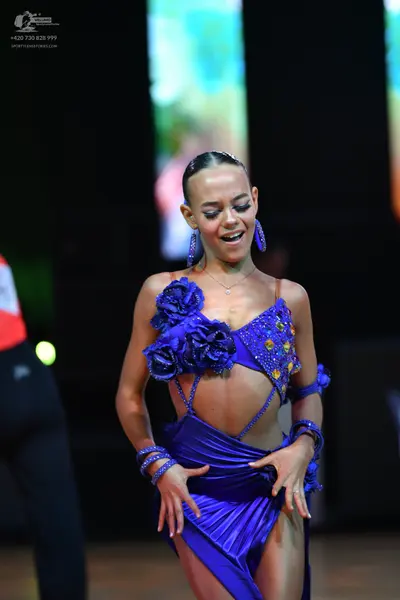 Dancesport competitor: Female dancer: Royal blue latin dress with satin-like fabric, featuring large fa