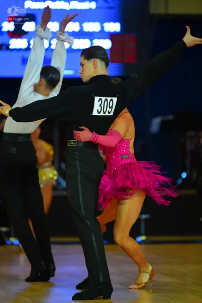 Dancesport competitor #309: Male dancer in foreground: black long-sleeved top and black trousers