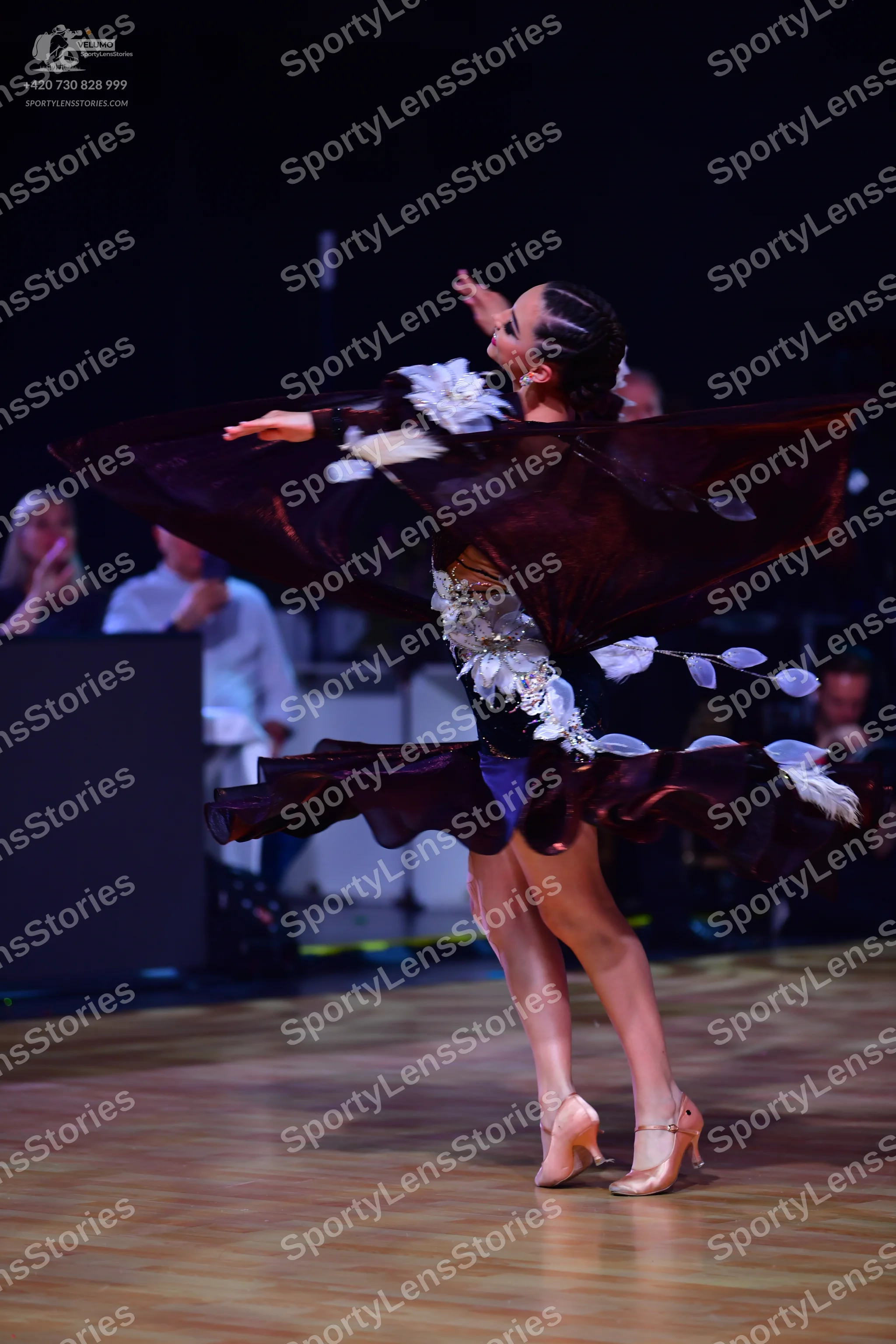 Dancesport competitor: Female dancer: dark burgundy Latin dance dress with large, voluminous, ruffled f