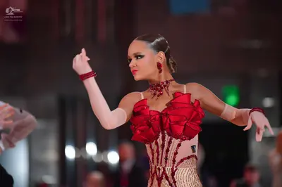 Dancesport competitor #31: Female dancer: red latin dress with large red satin ruffles on the bodice, nude-