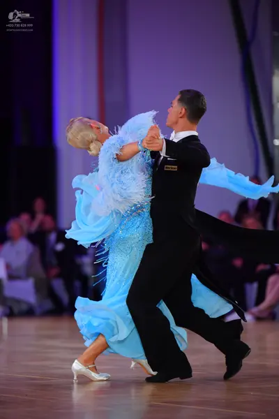 Dancesport competitor: Female dancer: light blue ballgown with a voluminous, flowing skirt and textured