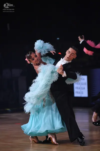 Dancesport competitor: Female dancer: light blue ballgown with voluminous light blue feather trim