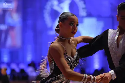 Dancesport competitor: Female dancer: black latin dress with silver sequins, featuring thin straps and 