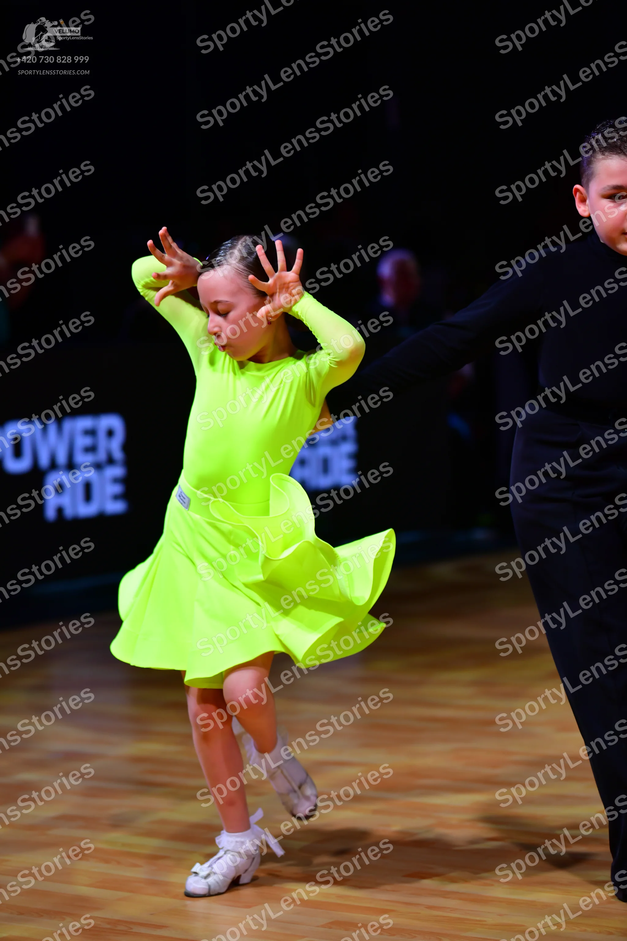 Dancesport competitor: Female dancer: neon yellow long-sleeved Latin dress with a ruffled skirt