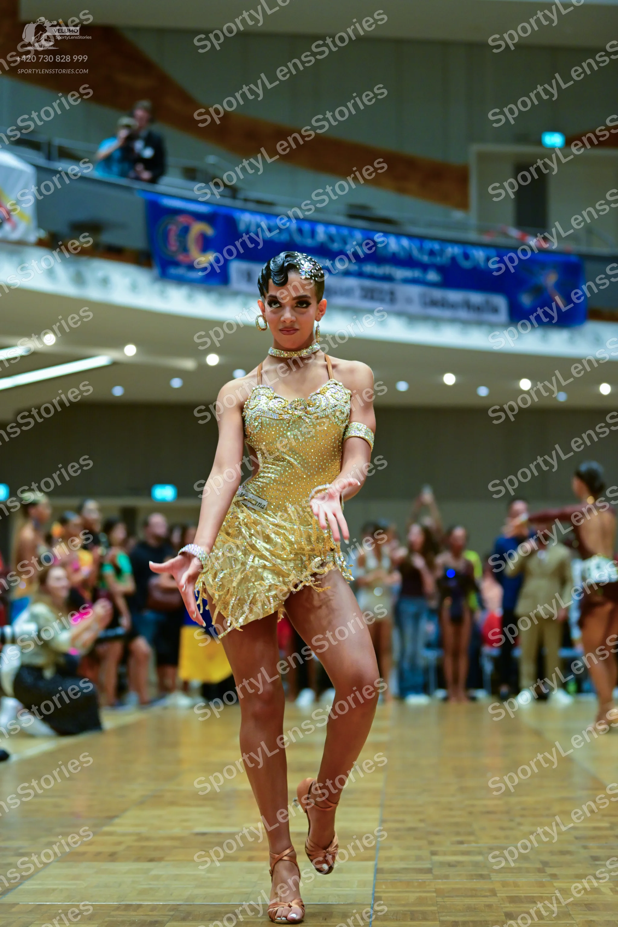 Dancesport competitor: Female dancer: champagne-colored Latin dress with heavy sequin and bead embellis