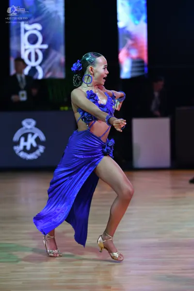 Dancesport competitor: Female dancer: bright blue latin dress with satin-like fabric, featuring blue fl
