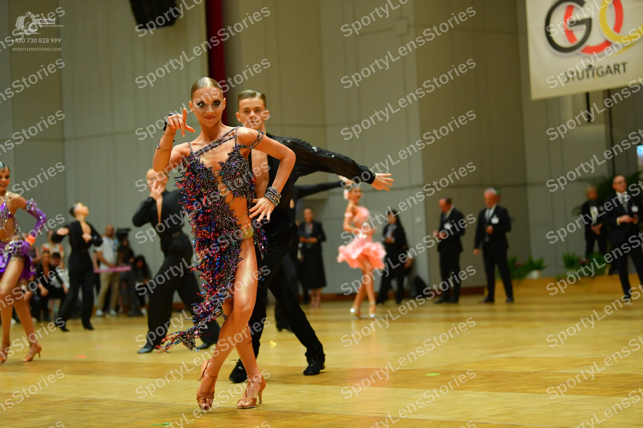 Dancesport competitor: Main female dancer: dark blue and multi-colored sequined Latin dance dress with