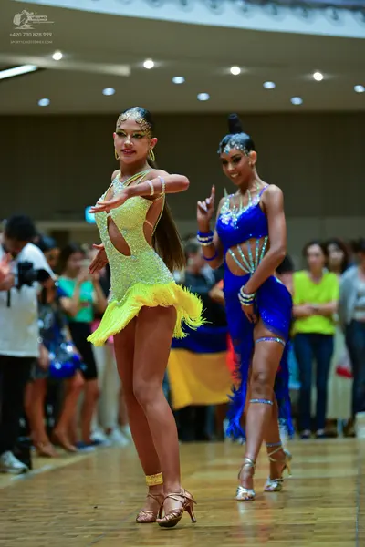 Dancesport competitor: Female dancer 1: lime green latin dress with sequins, side cut-outs, and a feath