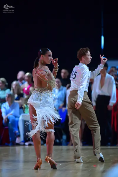 Dancesport competitor #65: Female dancer: white and gold latin dress with sequins, beads, and long fringe; 