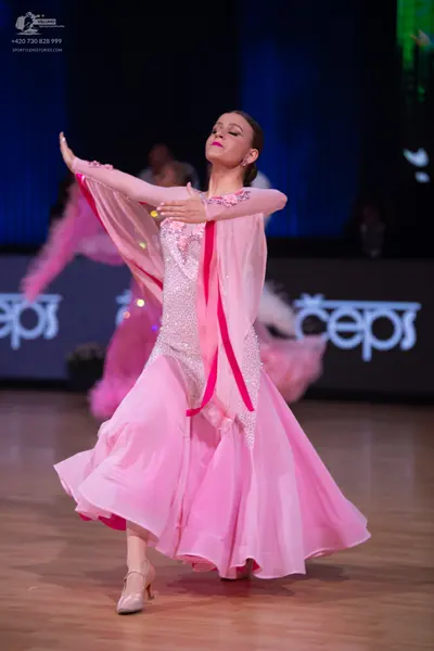 Dancesport competitor: Female dancer: light pink ballroom dress with a sequin-embellished bodice, long 
