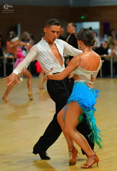 Dancesport competitor: ** Male:  Black suit with a high collar, white undershirt, and brown dance shoes