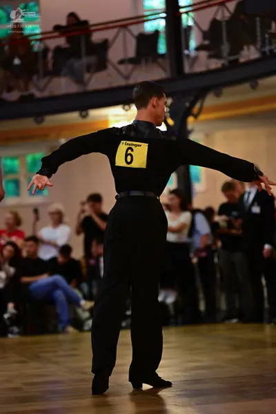 Dancesport competitor: Male dancer: black long-sleeved shirt with a shiny, satin-like upper section and