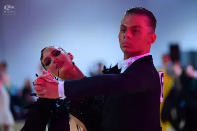 Dancesport competitor: Male dancer: black suit with a white shirt and white bow tie