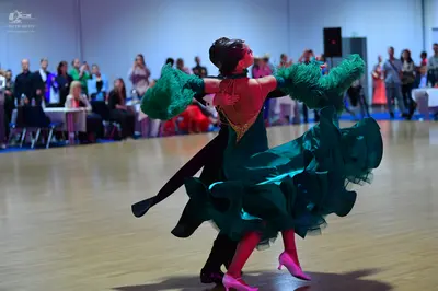 Dancesport competitor: Female dancer: green multi-layered ruffled Latin dress with golden/brown embelli