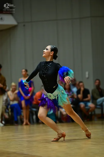 Dancesport competitor: Female dancer: black long-sleeved bodysuit with a lace-up bodice, a multi-colore