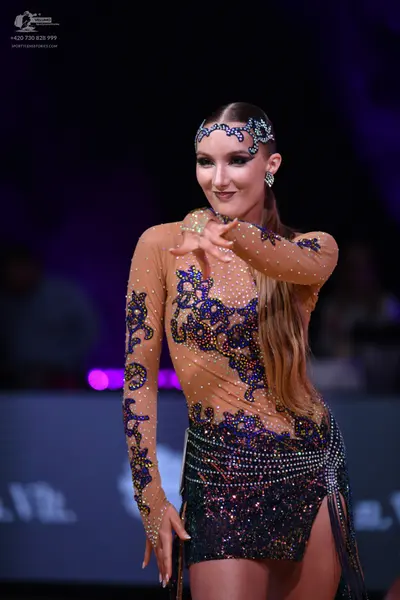 Dancesport competitor: Female dancer: nude-colored long-sleeved Latin dance dress with blue and purple 